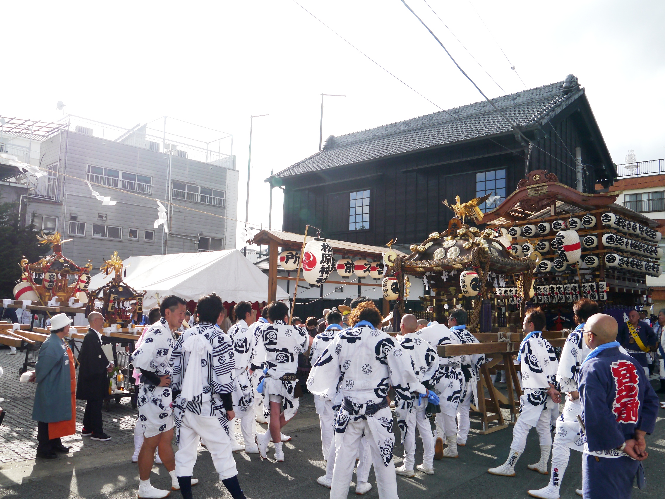 Festival scene with a mikoshi portable shrine and people wearing happi coats