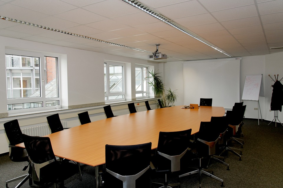 An empty meeting room with a long table and chairs